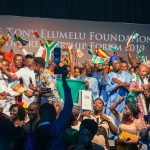 Image from Google.org depicting many people in front of a Tony Elumelu Foundation banner