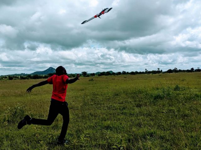 Healthtech: Patrick Kalonde, one of the drones pilots, stands beneath the drone as it takes off in the Kasungu district in Malawi. May 30, 2020. Photo: Thomson Reuters Foundation/ Handout via Kennedy Zembere for Malawi Liverpool Wellcome Trust