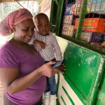 Kenyan housekeeper Brenda Vitute withdraws cash from an agent working for mobile money service M-pesa in Nairobi, Kenya on May 25, 2022. Thomson Reuters Foundation/Nita Bhalla
