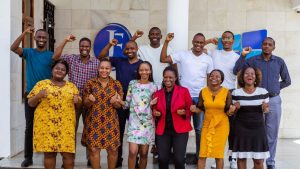 The JamiiForums team pose for a photo with their fists raised from their office in Dar es Salaam, Tanzania. Photo: Thomson Reuters Foundation/Yohana Haule