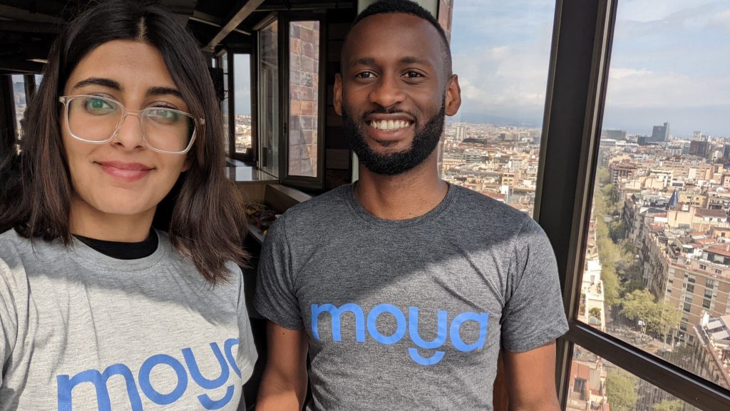 Image of Moya Money cofounders wearing Moya Money branded t-shirts with a city view behind them