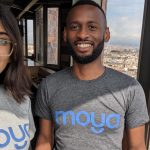 Image of Moya Money cofounders wearing Moya Money branded t-shirts with a city view behind them